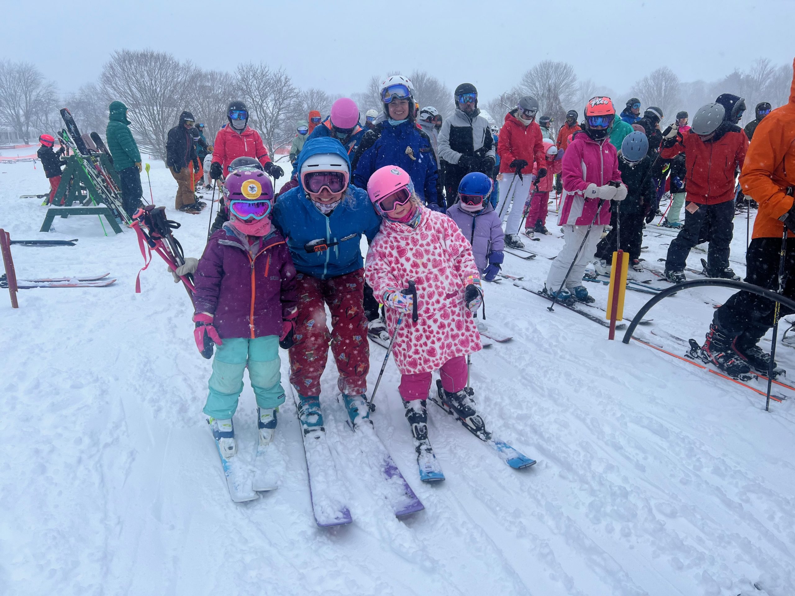 Skiers in line to get on the lift on a snowy day.