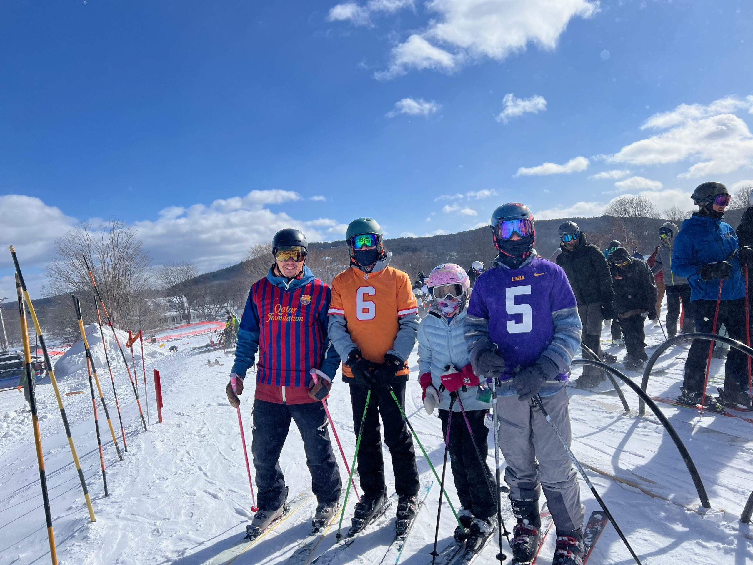 Skiers wearing sports jerseys at the base of the mountain.