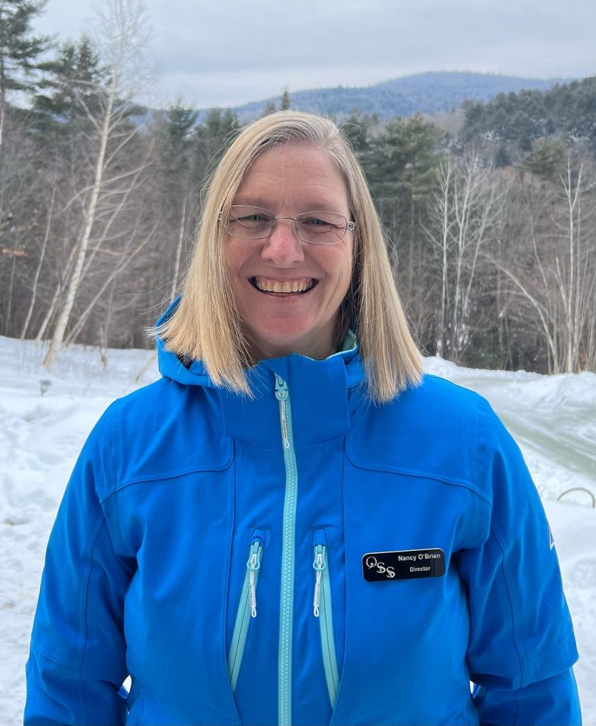 Nancy O'Brien in a blue jacket on the snowy mountain