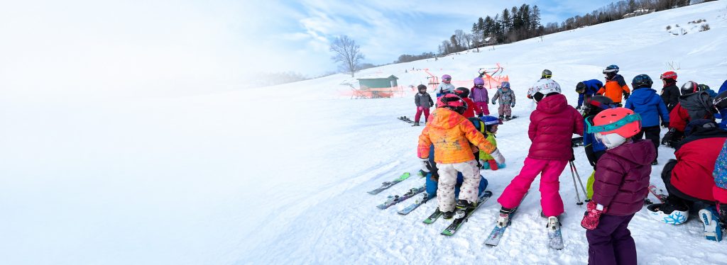 Young skiers at the bottom of the hill for the Ski Bees Program